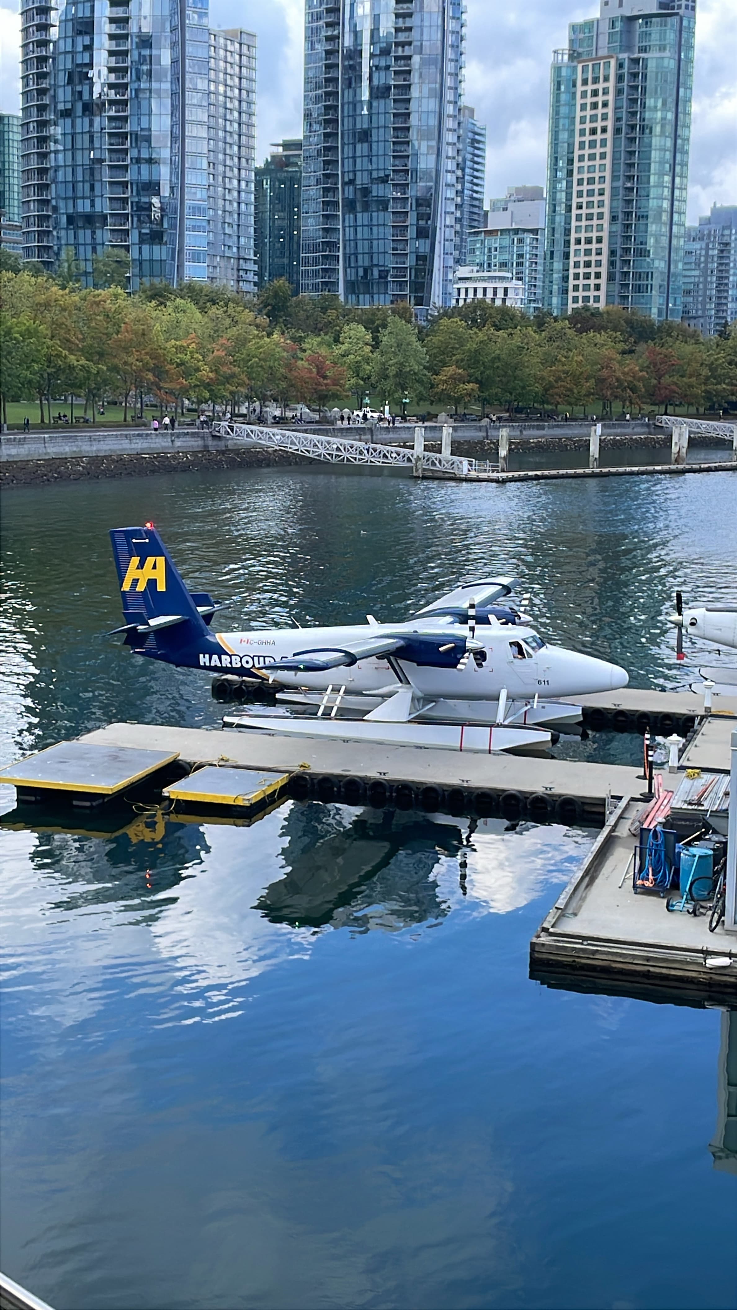 De Havilland Canada DHC-6 Twin Otter moored beside a pontoon over calm water.