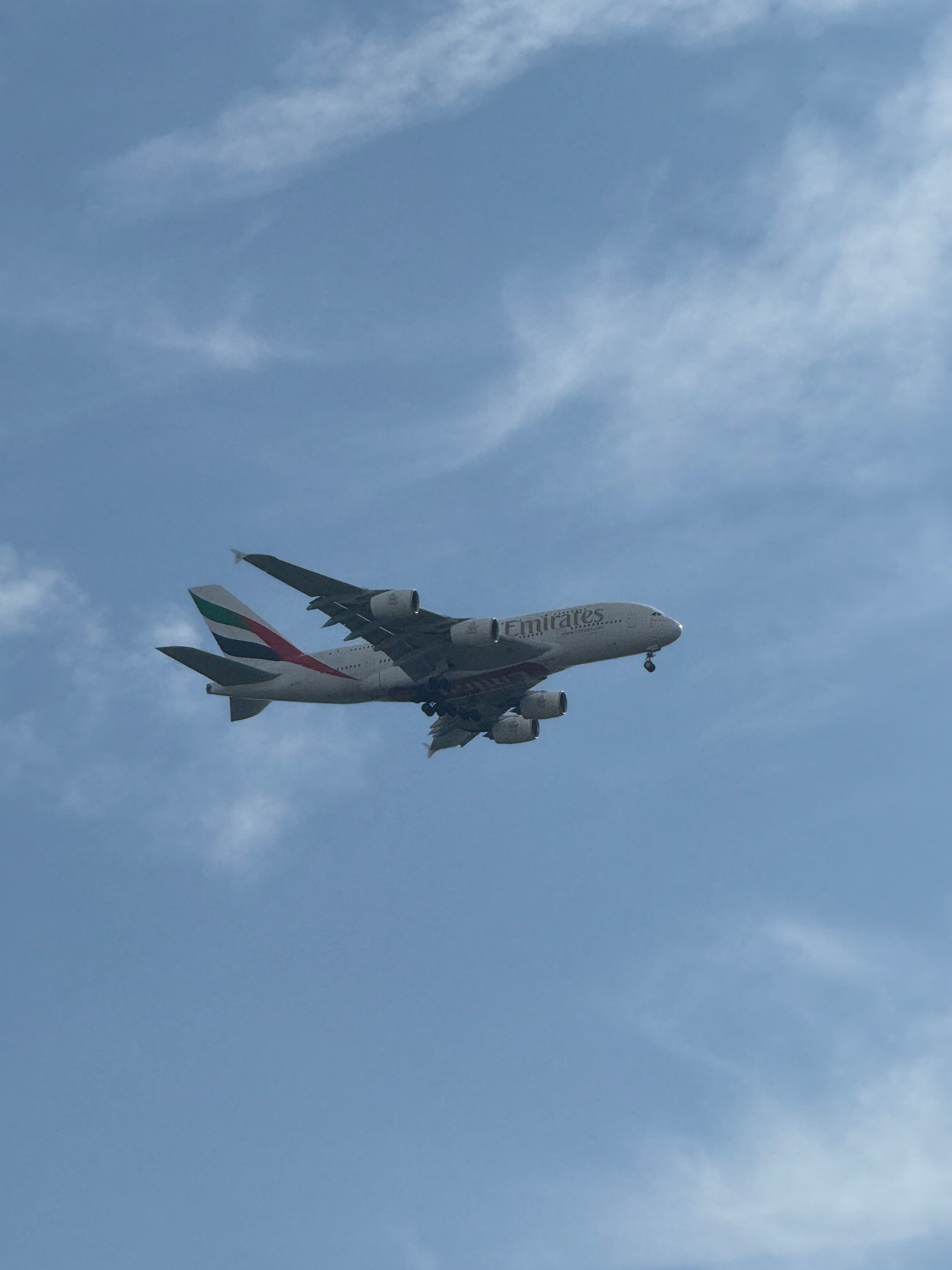 Airbus A380-800 with landing gear down against a blue sky.